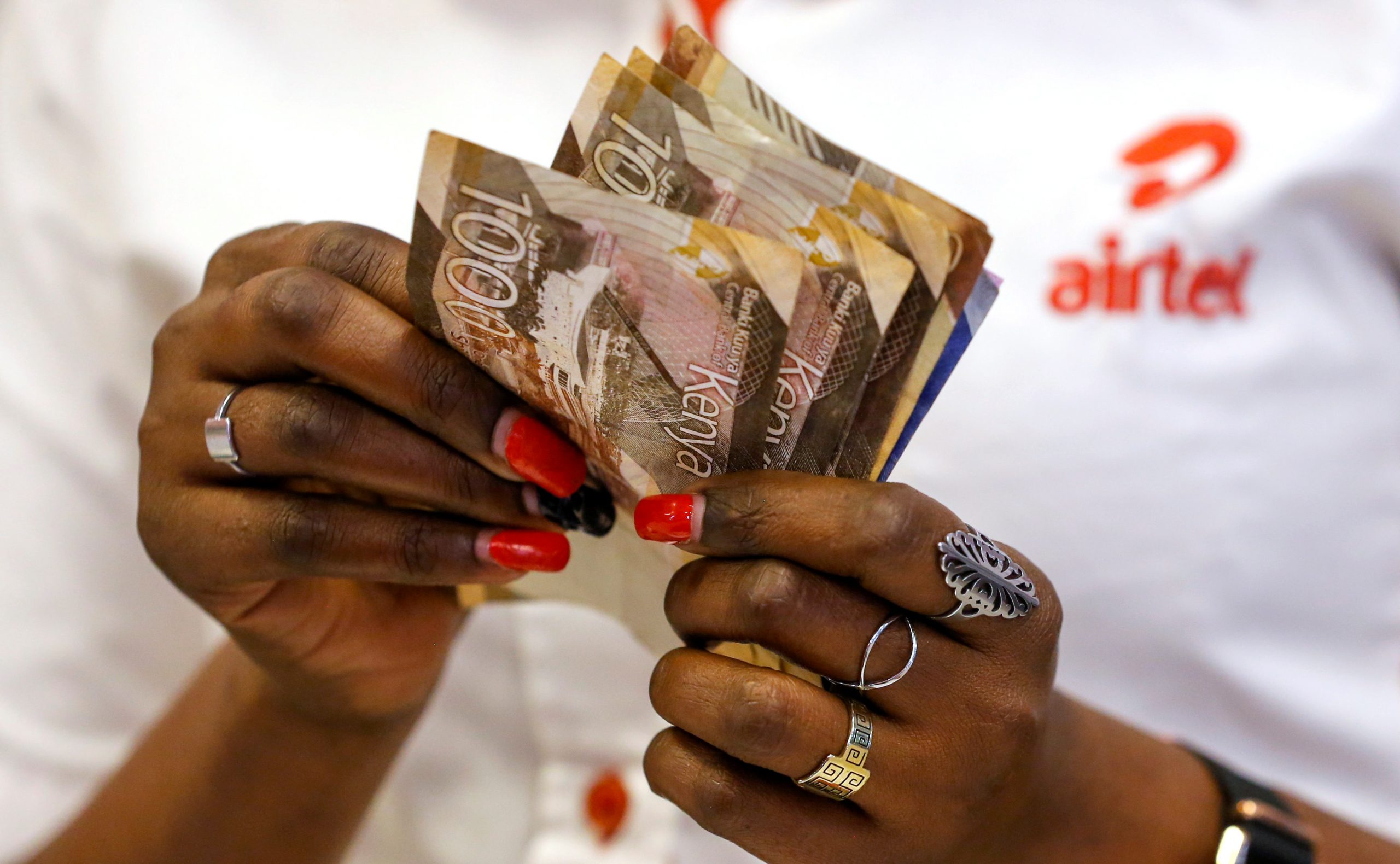 An employee counts money inside a mobile phone service centre operated by Airtel Kenya in Nairobi, Kenya January 29, 2021.