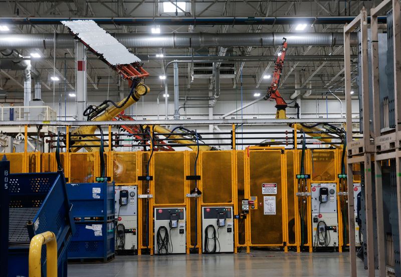 Robotic arms move material through the assembly process at the Magna Electric Vehicle Structures Facility, the manufacturing facility that builds battery enclosures for electric (EV) vehicles, in St. Clair, Michigan