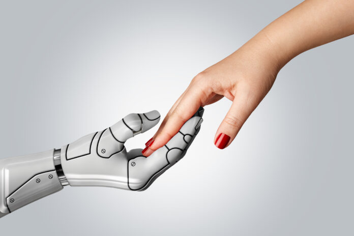 Robotic cyborg hand holding female human hand