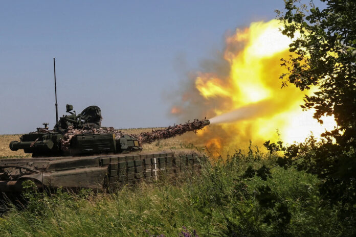 Ukrainian servicemen fire with a tank towards Russian troops near a front line in Kharkiv region