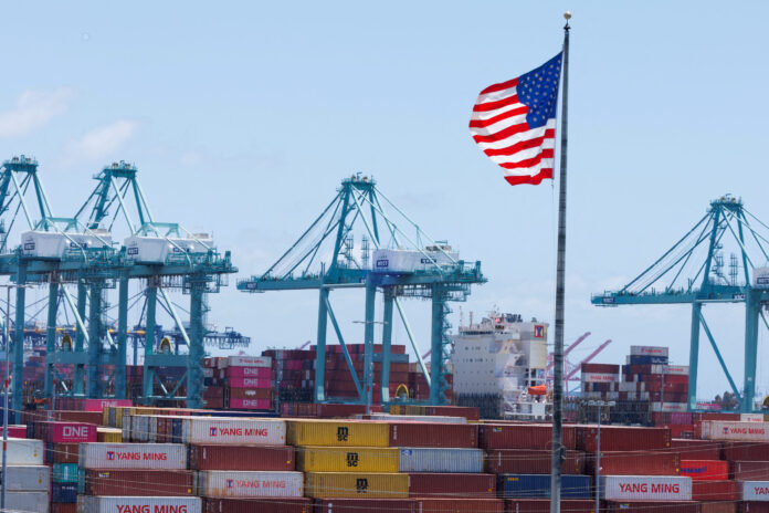 FILE PHOTO: The American flag flutters near a ship at Port of Los Angeles