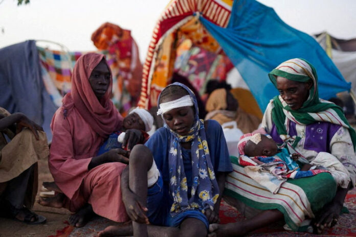 The grandmother of Ikram Abdelhameed looks on next her family while sitting at a camp for displaced people who fled from al-Fashir to Tawila